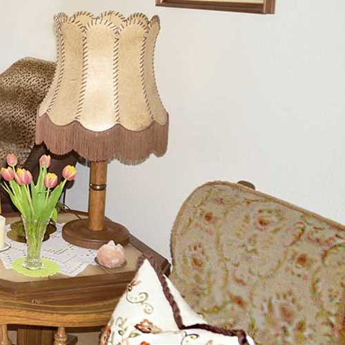 Lampe, Sessel und Tisch mit Blumen